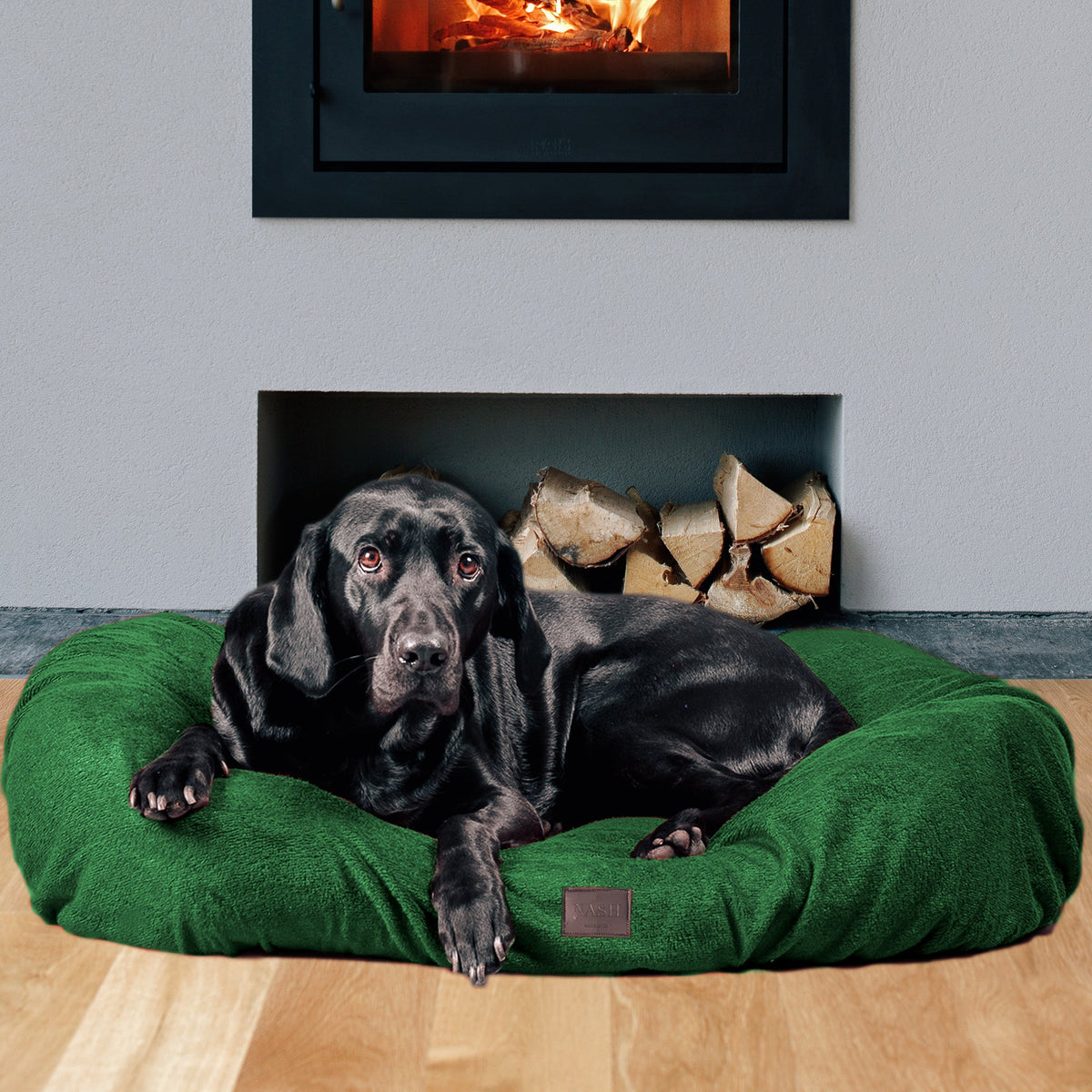 Labrador resting at home on its bed. The bed is covered with the NASH forest green bamboo dog bed cover.