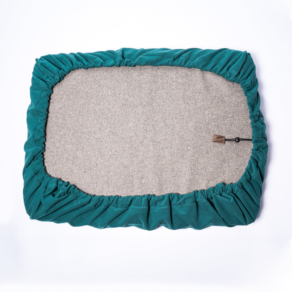 The underside of a dog bed, covered with a NASH waterproof microfleece dog bed cover, featuring adjustable drawstring.