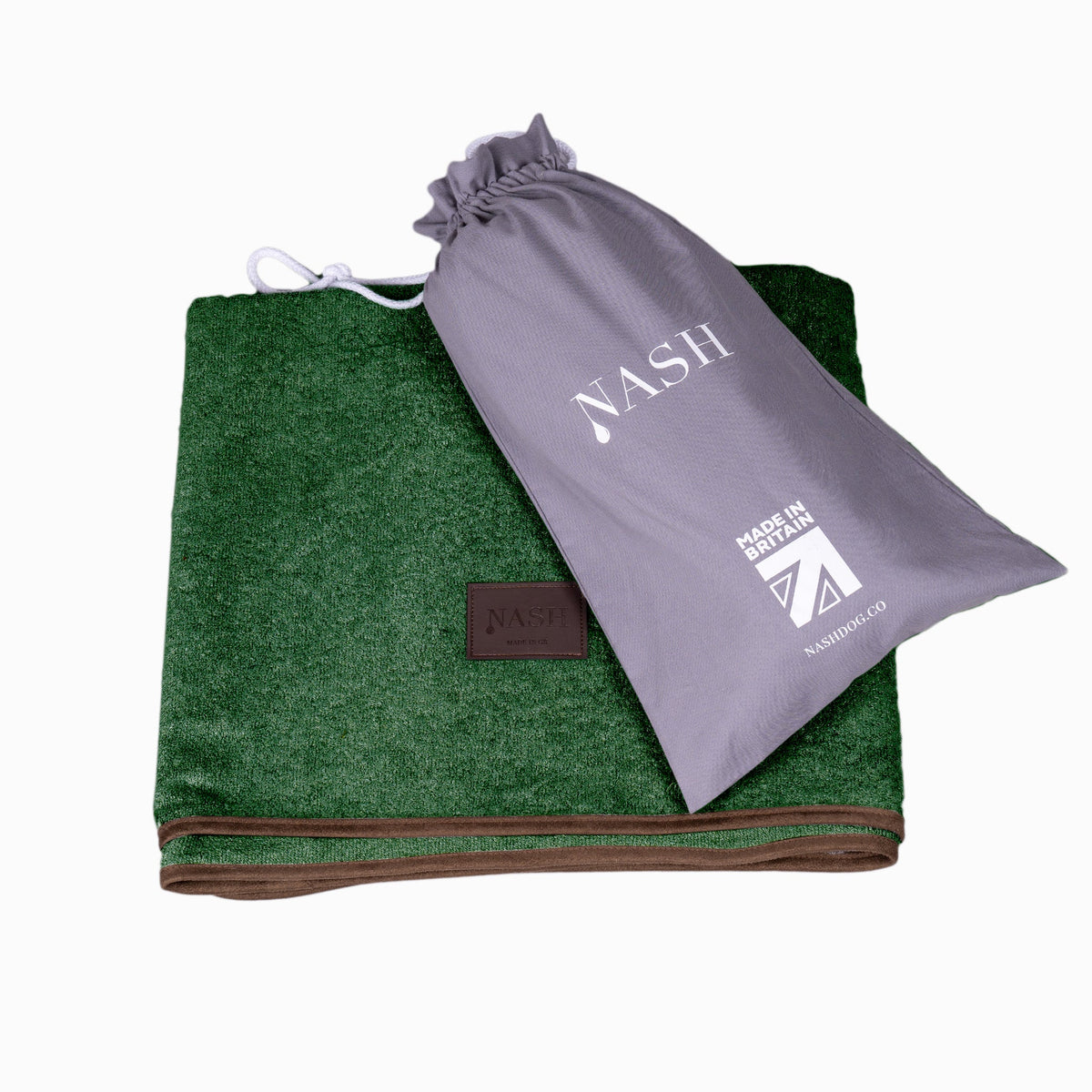 Folded NASH bamboo dog throw in forest green with its reusable bag placed on top.