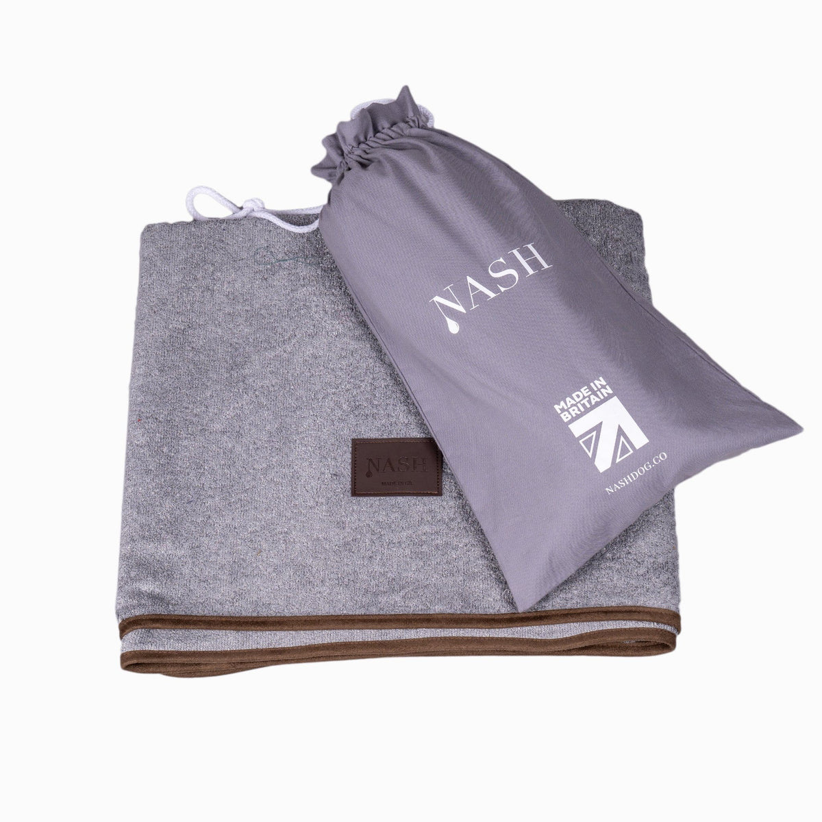 Folded NASH bamboo dog throw in grey and its reusable bag placed on top.